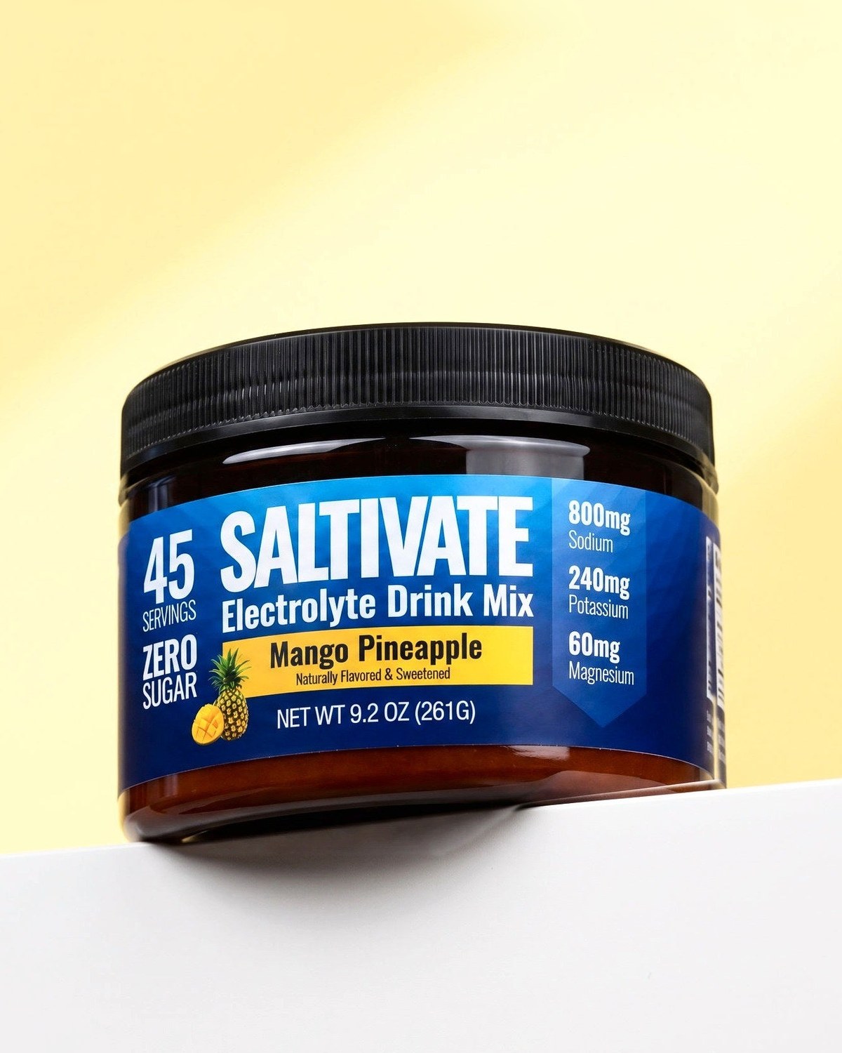 Saltivate Mango Pineapple jar on a white ledge against a pale butter yellow backdrop