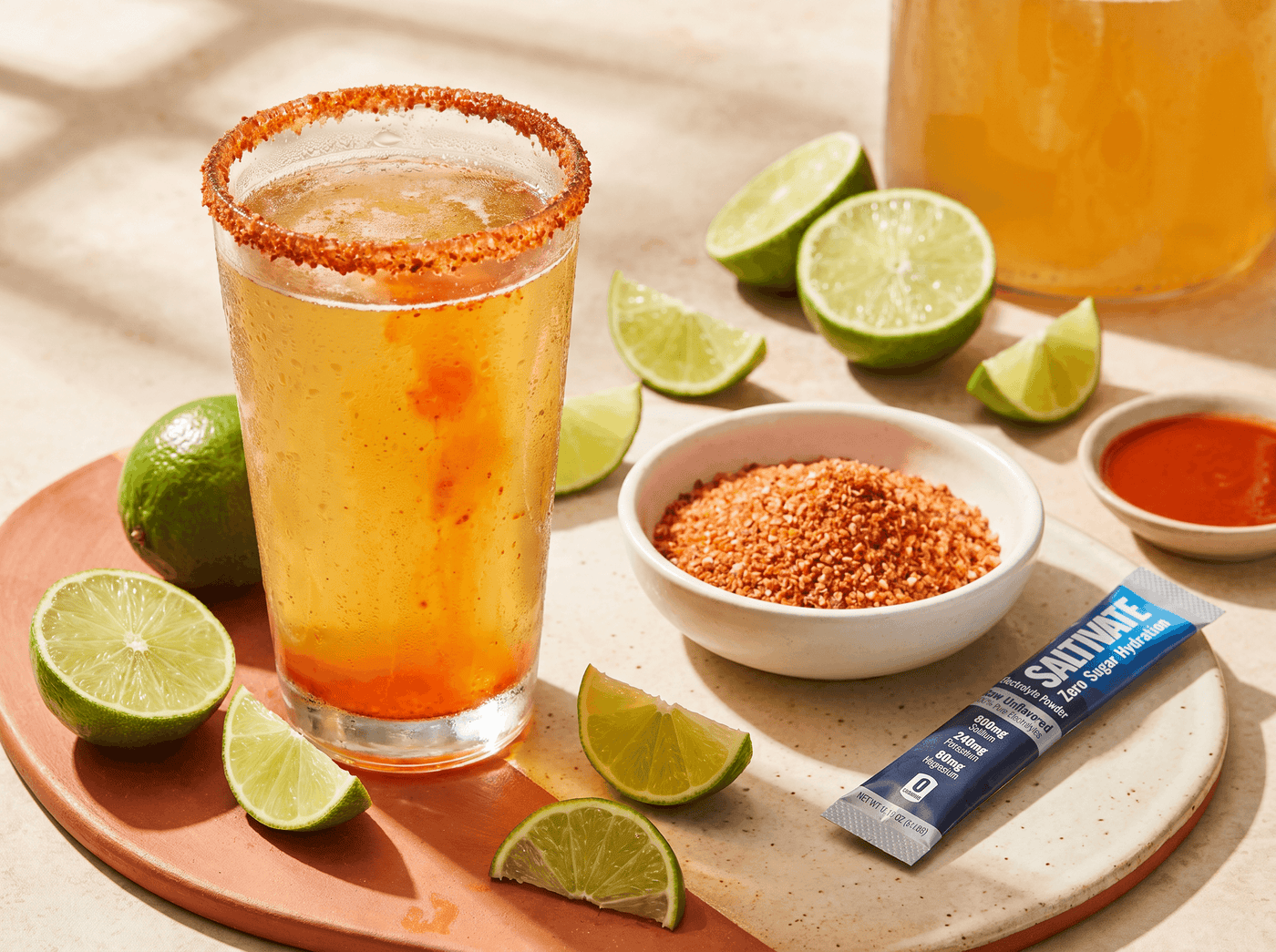 Electrolyte michelada with a chile-salt rim, lime wedge, and a Saltivate stick packet