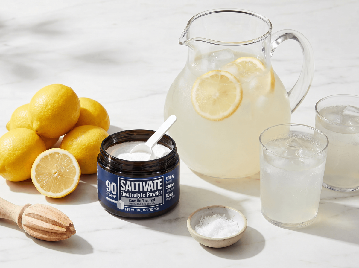 Pitcher of salted electrolyte lemonade with lemons and an open jar of Saltivate Raw Unflavored