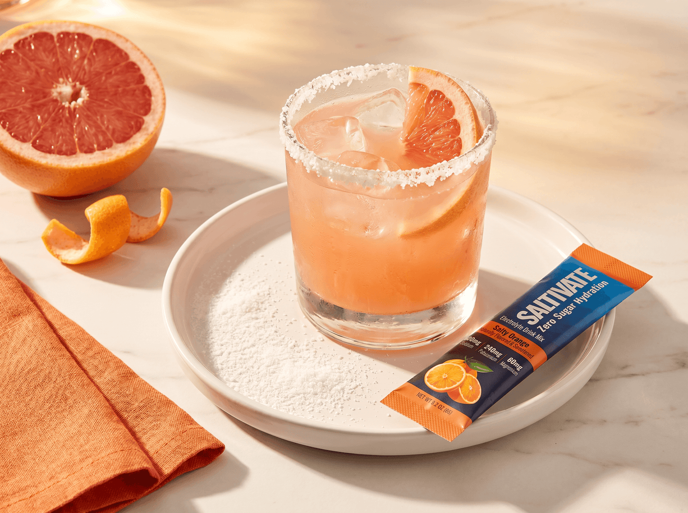Salty dog cocktail with a white Saltivate electrolyte rim and pink grapefruit juice