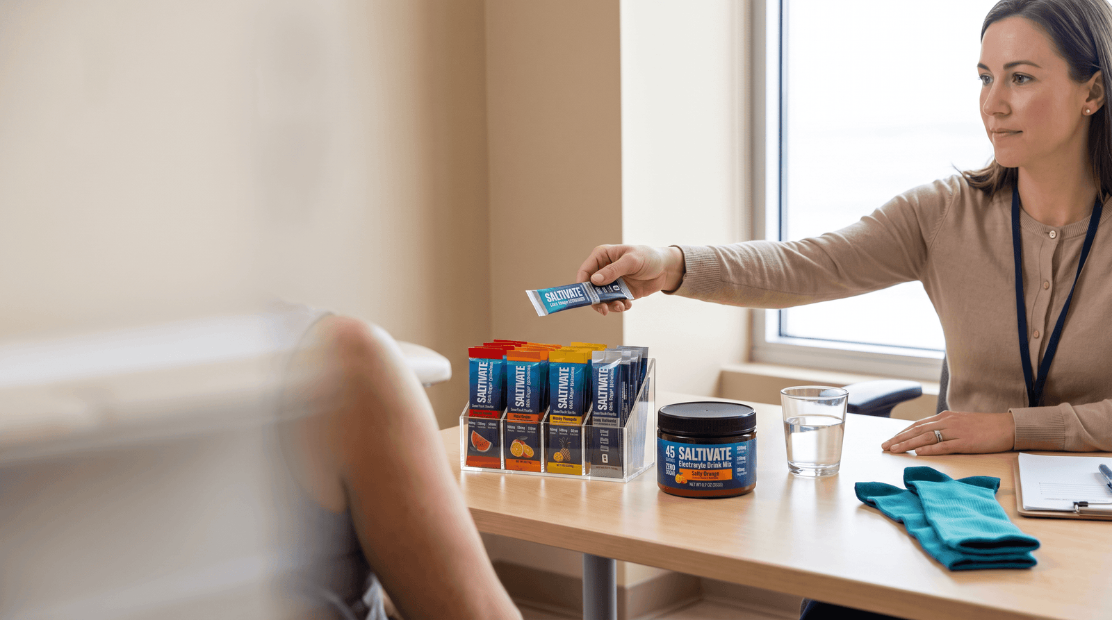 Dietitian handing a Saltivate stick pack to a patient across a consult-room desk