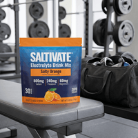 Saltivate Salty Orange 30-count stick pack pouch on a gym bench beside a duffel bag
