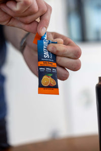 Hands tearing open a Salty Orange stick