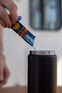 Pouring a Salty Orange stick into a water bottle