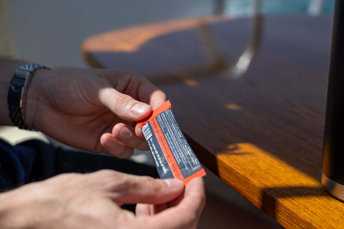 Hands reading the ingredient label on the back of a Saltivate stick