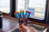 Hand fanning out the three Saltivate stick pack flavors