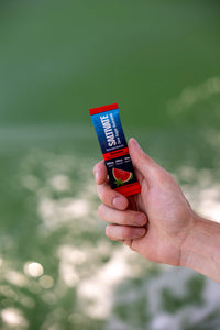 Hand holding a Saltivate Watermelon stick pack over open water