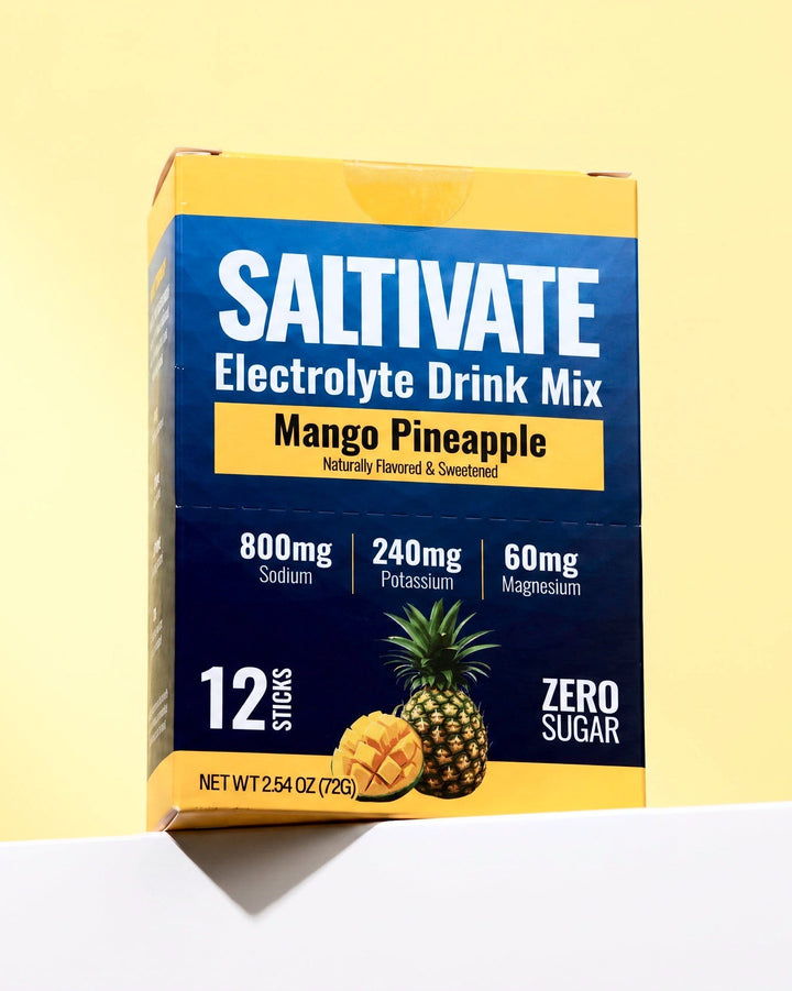Saltivate Mango Pineapple 12-stick carton on a white ledge against a pale butter yellow backdrop