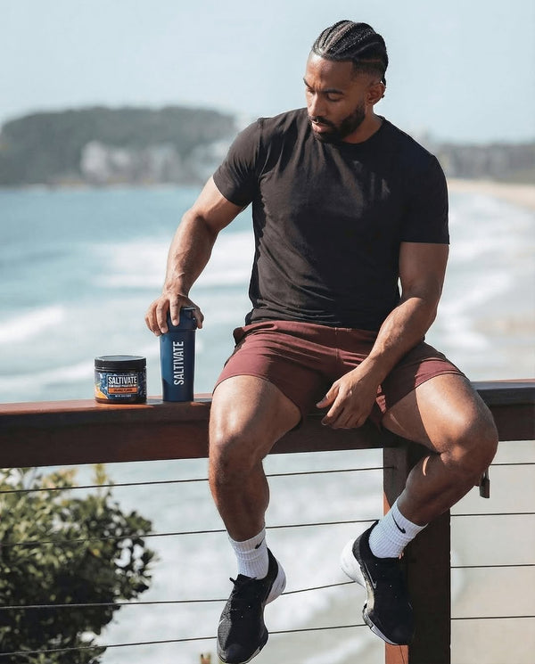 Man at beach railing with Saltivate Orange jar and ocean view