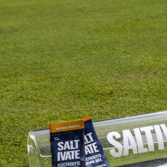 Saltivate bottle and Mango Pineapple packets on a golf green