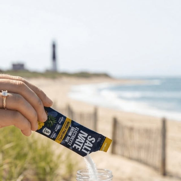 Mixing a Saltivate stick into a bottle on the beach