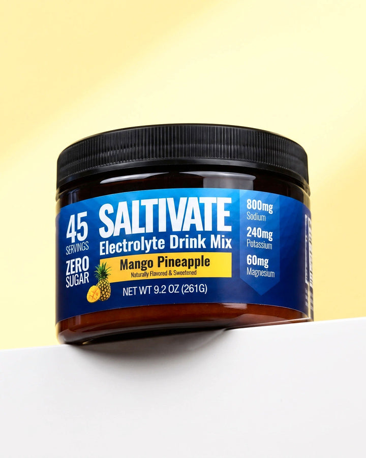 Saltivate Mango Pineapple jar on a white ledge against a pale butter yellow backdrop