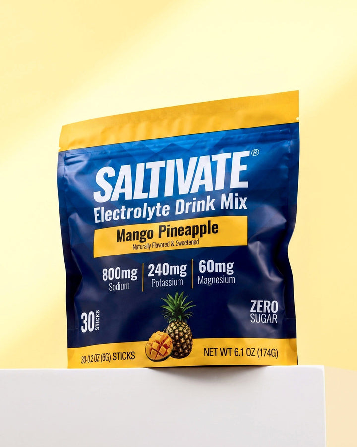 Saltivate Mango Pineapple 30-stick pouch on a white ledge against a pale butter yellow backdrop
