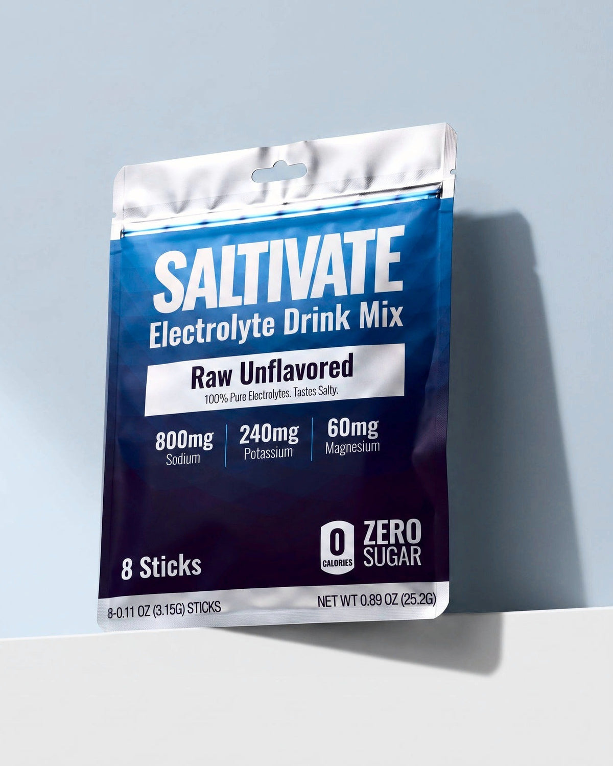 Saltivate Raw Unflavored 8-stick sample pouch on a white ledge against a pale blue-grey backdrop