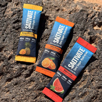 Saltivate Mango Pineapple, Salty Orange, and Watermelon sticks laid on volcanic rock in the Utah desert