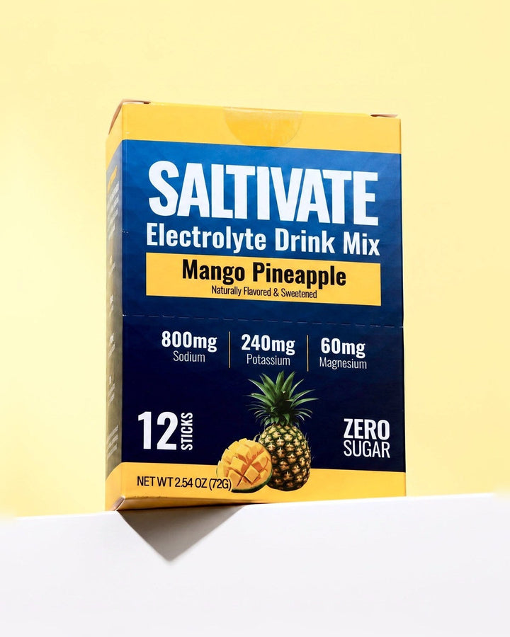 Saltivate Mango Pineapple 12-stick carton on a white ledge against a pale butter yellow backdrop