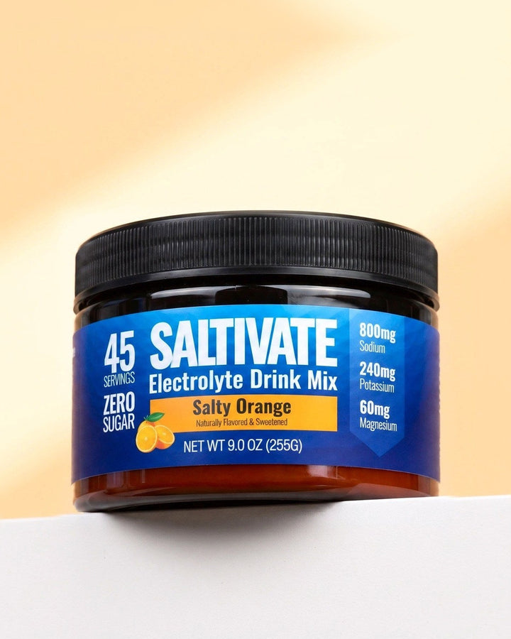 Saltivate Salty Orange jar on a white ledge against a pale peach backdrop