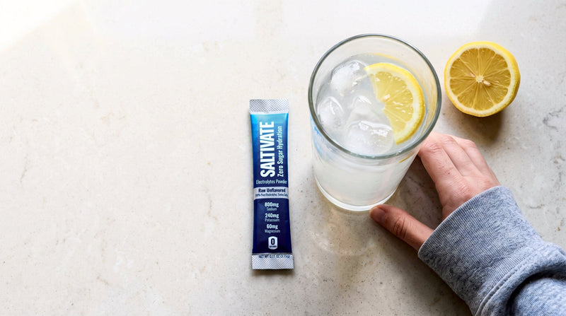 A Raw Unflavored packet beside an iced glass of lemon water, seen from above